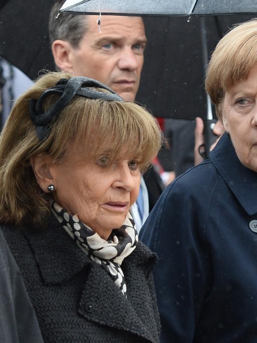 Bundeskanzlerin Angela Merkel (r, CDDU) geht am 03.05.2015 mit dem Präsidenten des Zentralrats der Juden, Josef Schuster (l), und der Präsidentin der Israelitischen Kultusgemeinde München und Oberbayern, Charlotte Knobloch, zur Zentralen Gedenkfeier anlässlich des 70. Jahrestags der Befreiung des Konzentrationslagers Dachau auf dem ehemaligen KZ-Gelände in Dachau (Bayern).