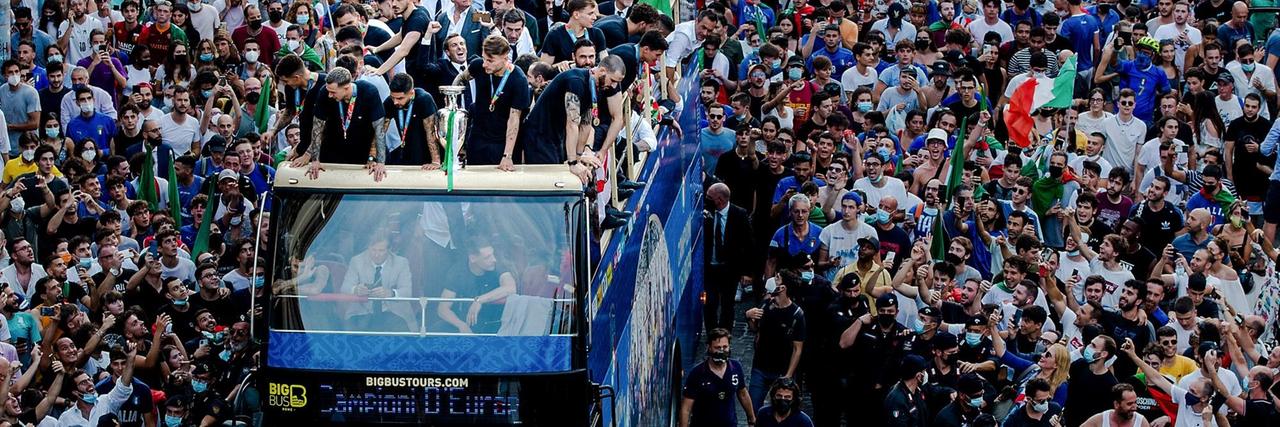 Fans jubeln den Spielern der italienischen Fußballnationalmannschaft zu, die auf dem offenen Bus ihren EM-Sieg feiern.
