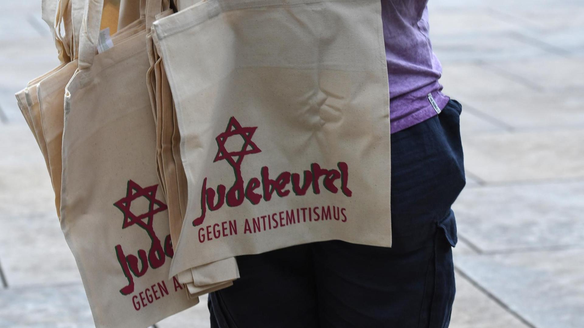 Eine Mann verteilt Einkaufsbeutel mit Davidstern und der Aufschrift: Judebeutel-Gegen Antisemitismus beim Kippa-Tag in Freiburg und der Demonstration gegen Antisemitismus, antisemitische Anfeindungen und Ausgrenzung.