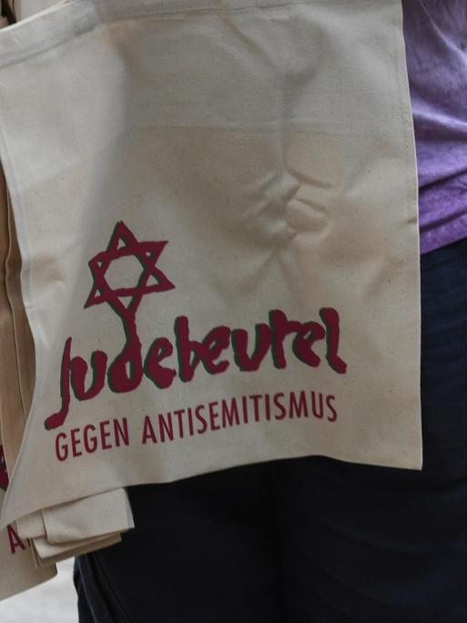 Eine Mann verteilt Einkaufsbeutel mit Davidstern und der Aufschrift: Judebeutel-Gegen Antisemitismus beim Kippa-Tag in Freiburg und der Demonstration gegen Antisemitismus, antisemitische Anfeindungen und Ausgrenzung.