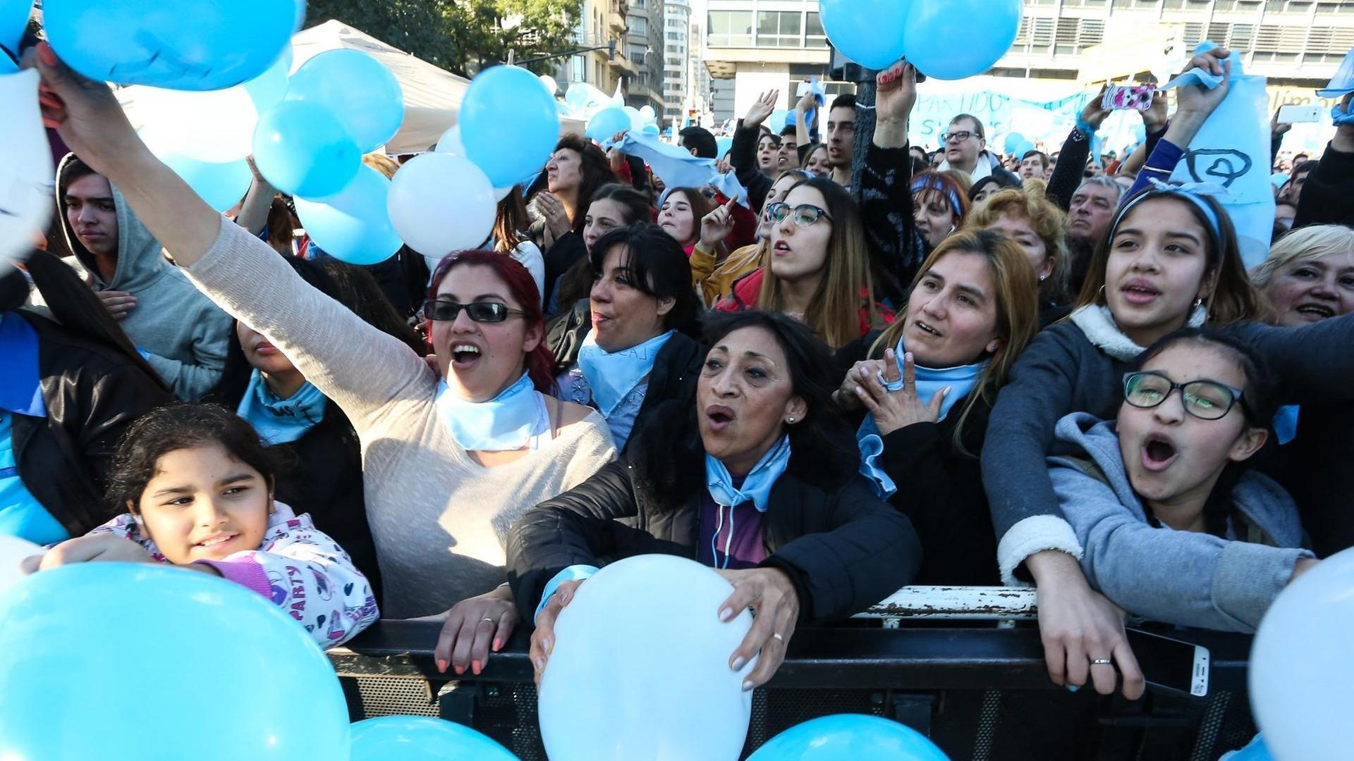 Frauen und Männer demonstrieren mit hellblauen Luftballons gegen eine Legalisierung der Abteibung in Argentinien.