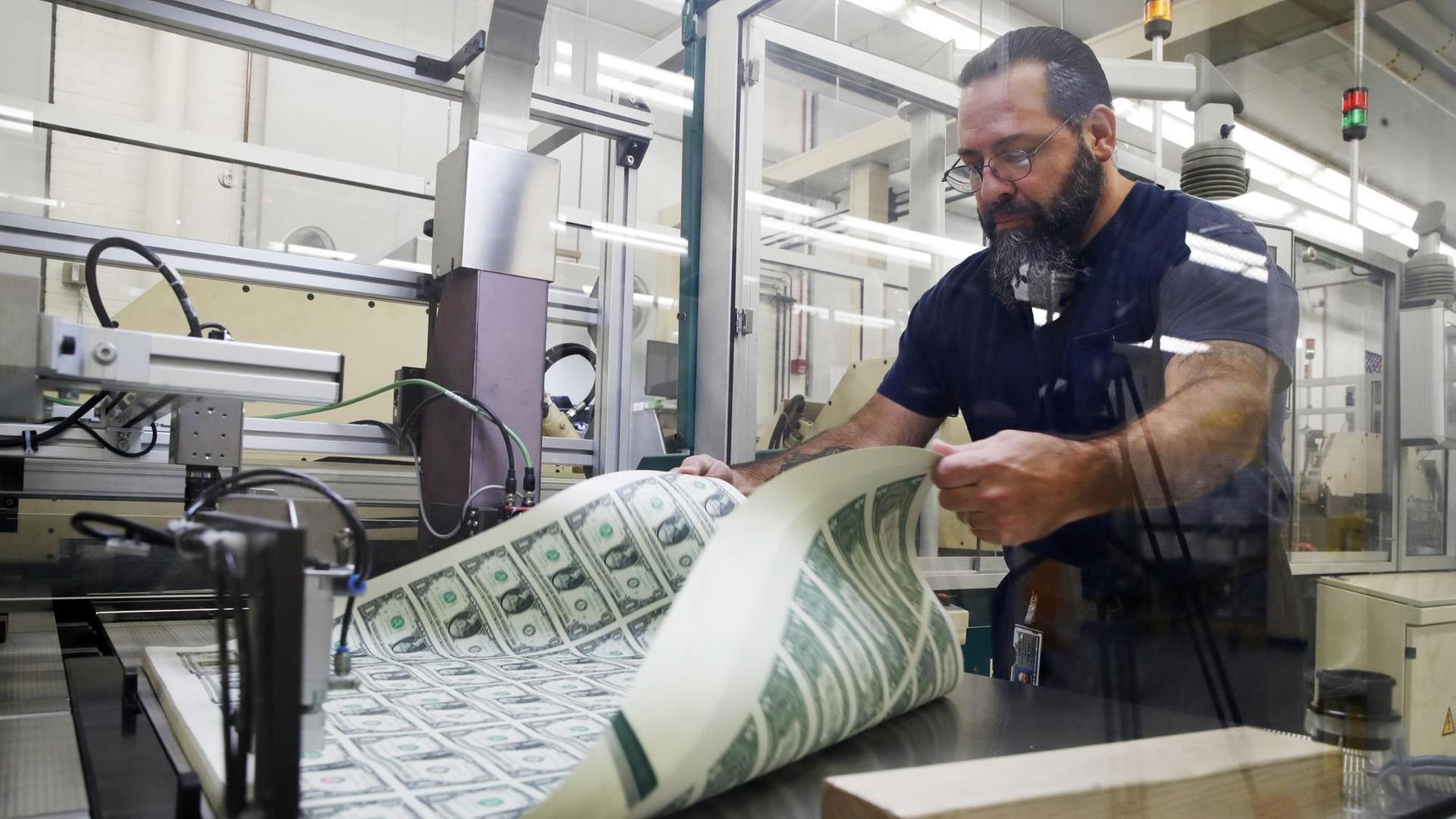 Mitarbeiter Vincent Tacconelli belüftet frisch gedruckte Bögen mit Dollarnoten in der US-Notendruckerei, dem Bureau of Engraving and Printing in Washington