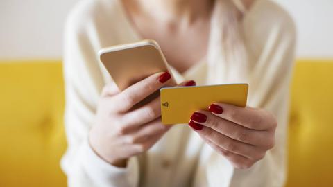Blonde woman using smartphone and using bank card at home model released Symbolfoto property released PUBLICATIONxINxGERxSUIxAUTxHUNxONLY EBSF02398