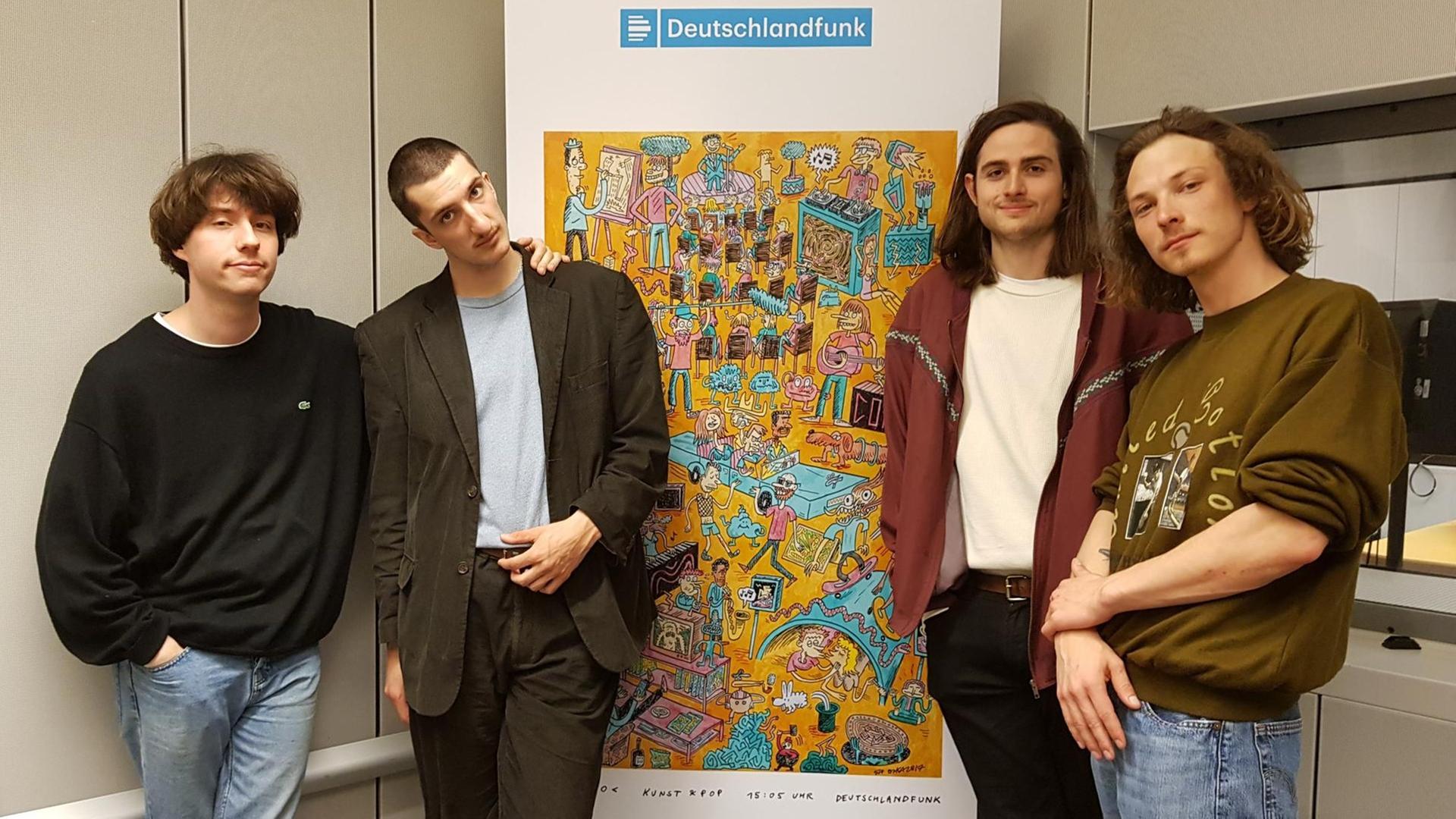 Die vier Stuttgarter Musiker der Band Rikas stehen vor dem Corso-Logo im Deutschlandfunk