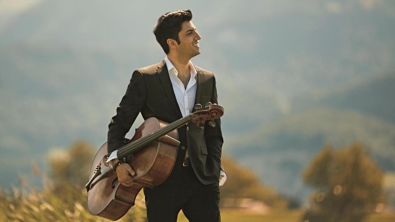 Kian Soltani mit Cello vor Landschaft