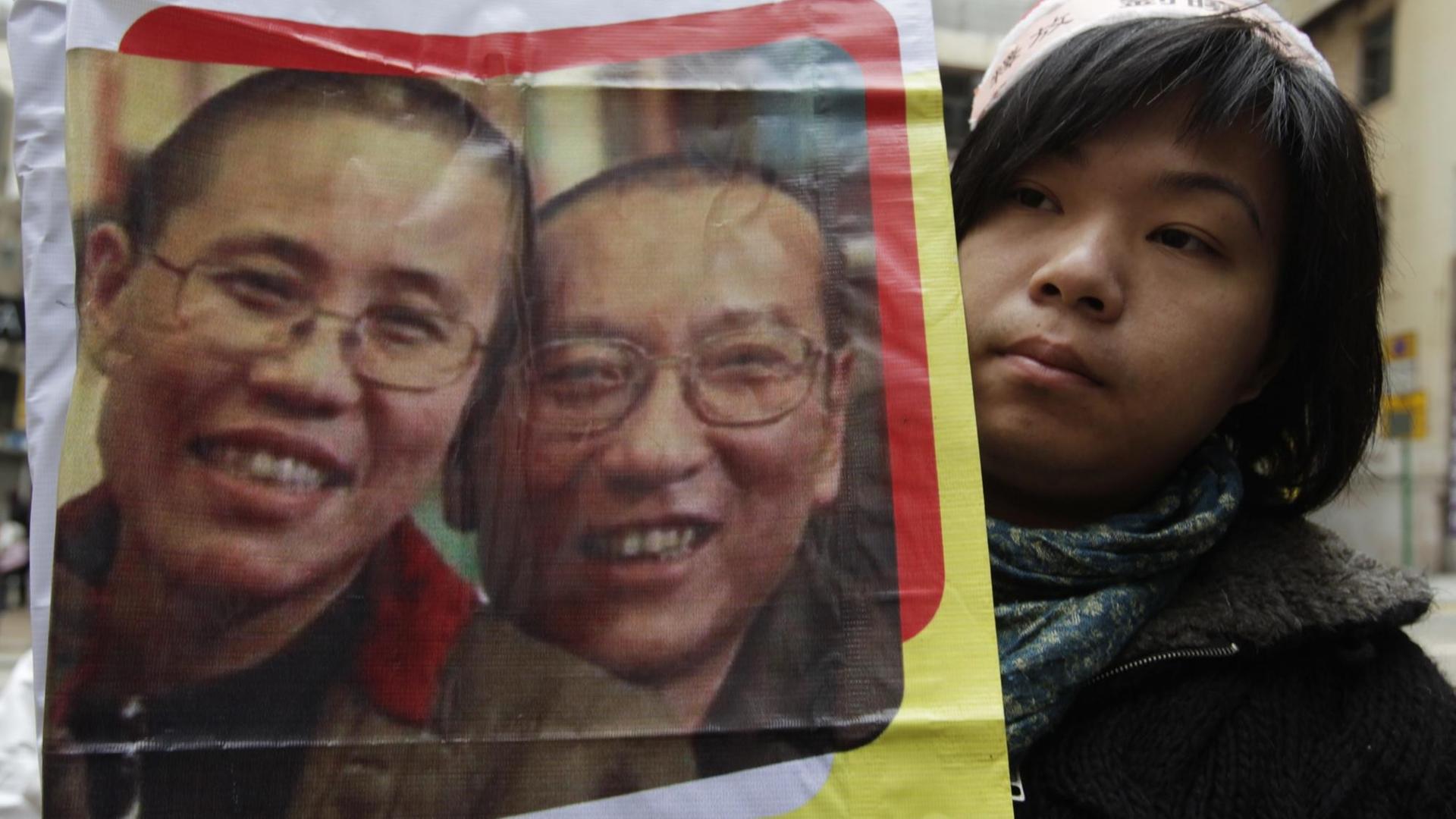 Eine Demonstrantin in China hält ein Bild von Friedensnobelpreisträger Liu Xiaobo und seiner Frau Lia Xia hoch (Archivbild aus dem Jahr 2010).