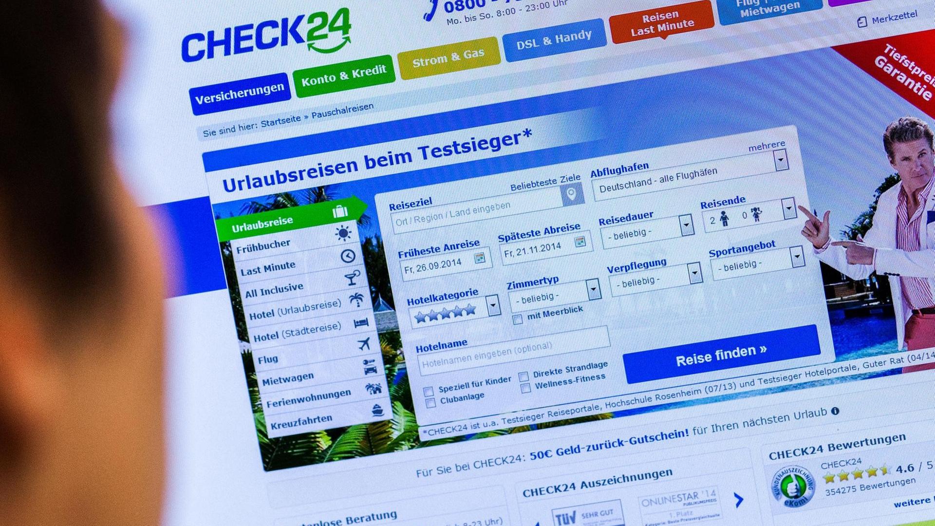 Ein junger Mann blickt am auf einen Computerbildschirm, auf dem die Webseite von Check24 zu sehen ist.