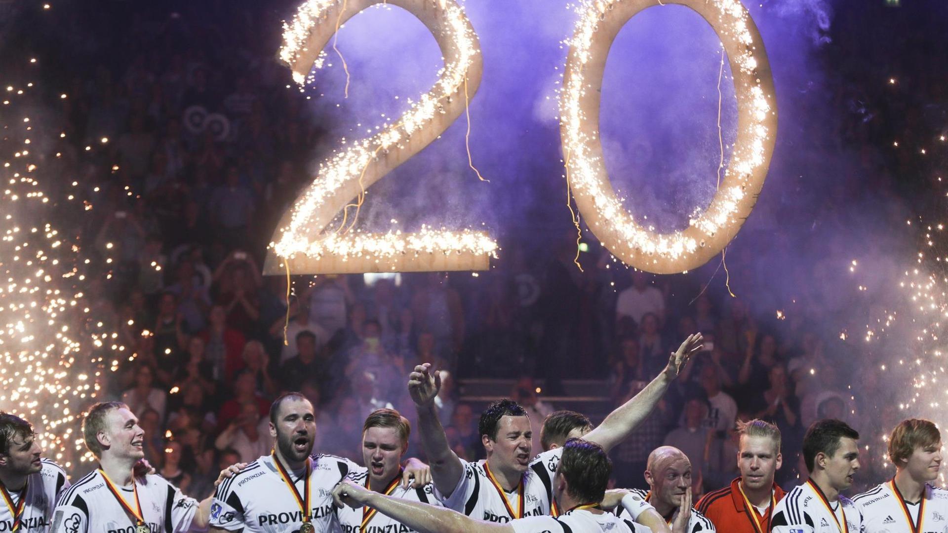 Die Spieler des THW Kiel feiern die 20. Deutsche Meisterschaft, im Hintergrund leuchtet die Zahl 20.