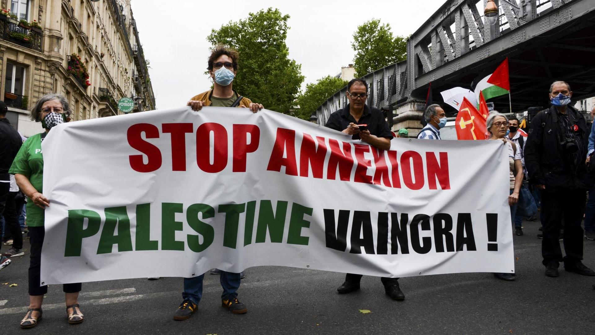 Demonstranten mit Bannern in Paris protestieren gegen die geplante Annexion des Westjordanlandes durch Israel.