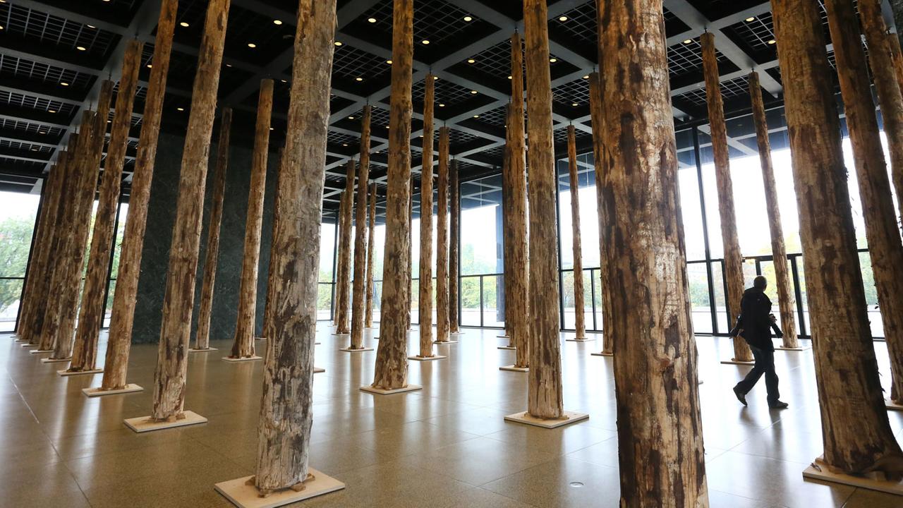 143 aufgestellte Baumstämme in der oberen Glashalle der Neuen Nationalgalerie in Berlin - die Installation "Sticks and Stones" des britischen Architekten David Chipperfield.