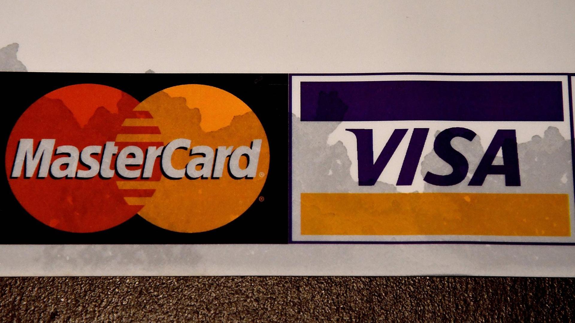 Eine Mastercard und eine Visakarte liegen nebeneinander. Eine Mastercard und eine Visakarte liegen nebeneinander.