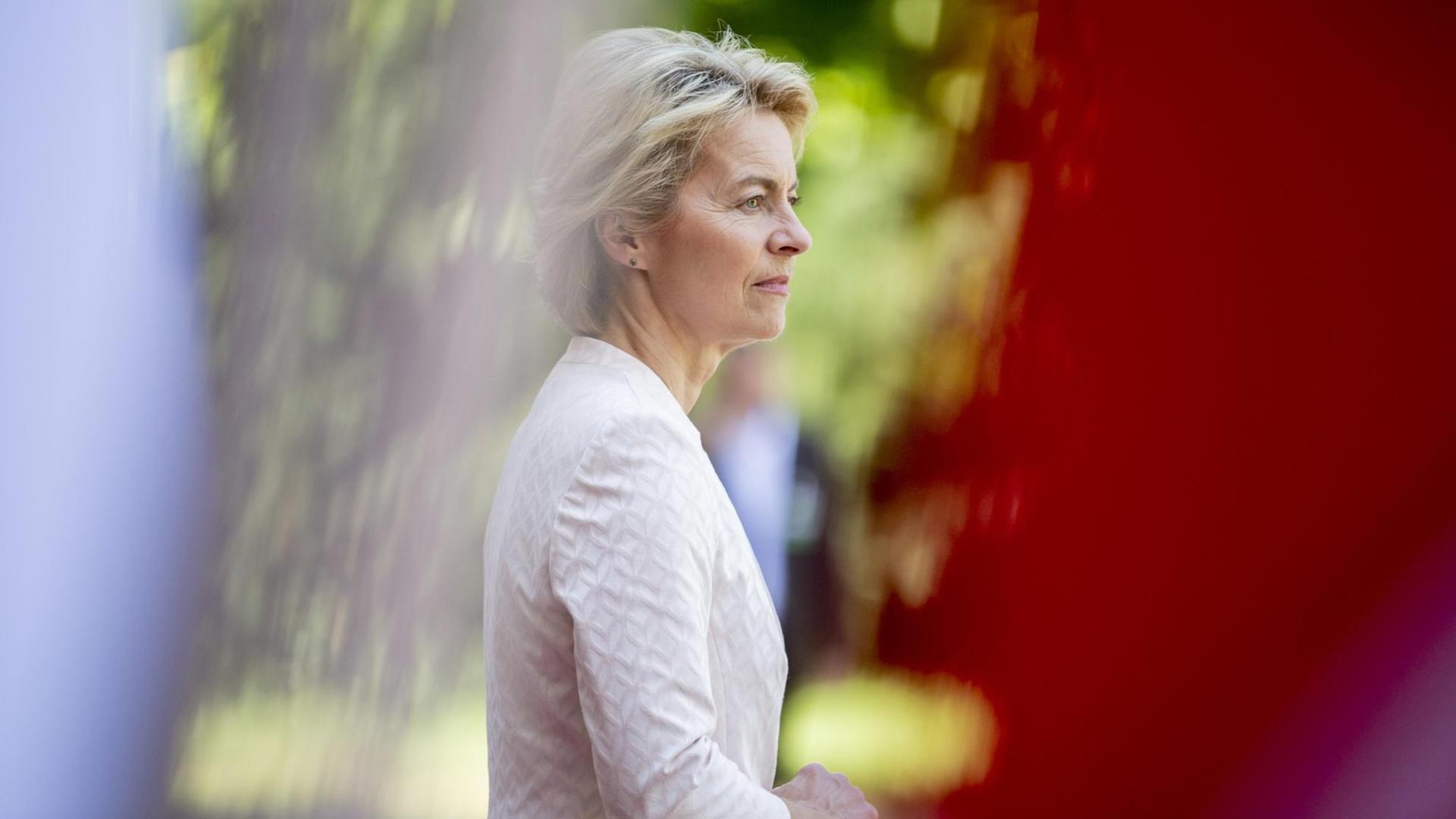 Ursula von der Leyen (CDU), Bundesverteidigungsministerin, steht hinter Flaggen