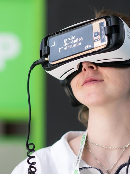 Eine Besucherin aus München schaut sich bei der Internetkonferenz "re:publica 2018" Virtual-Reality-Kurzfilme an.