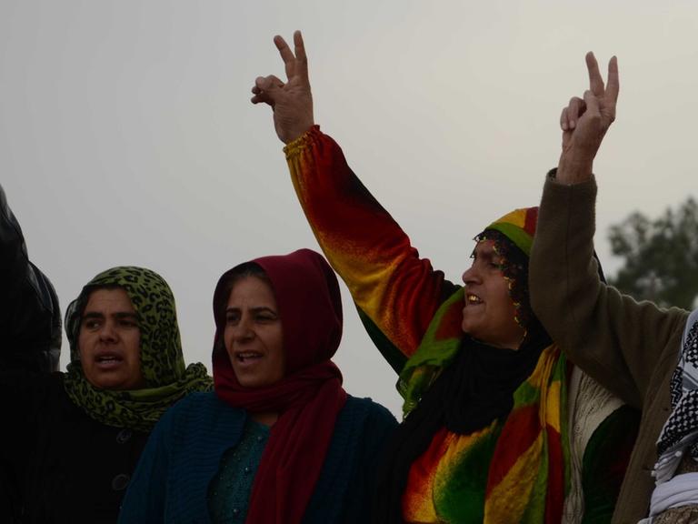 Aktivisten verlesen Neues von der Front in Kobane und die Menschen rufen Durchhalteparolen