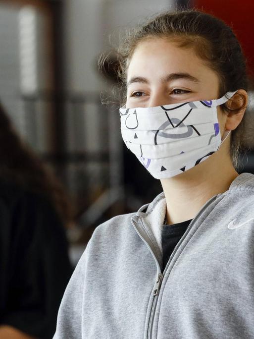 Realschule Benzenberg anlaesslich der Wiederaufnahme des Schulbetriebs unter Auflagen des Corona-Infektionsschutzes in Zeiten der Corona Pandemie, Schuelerinnen tragen Masken beim Unterricht im Musikraum.
