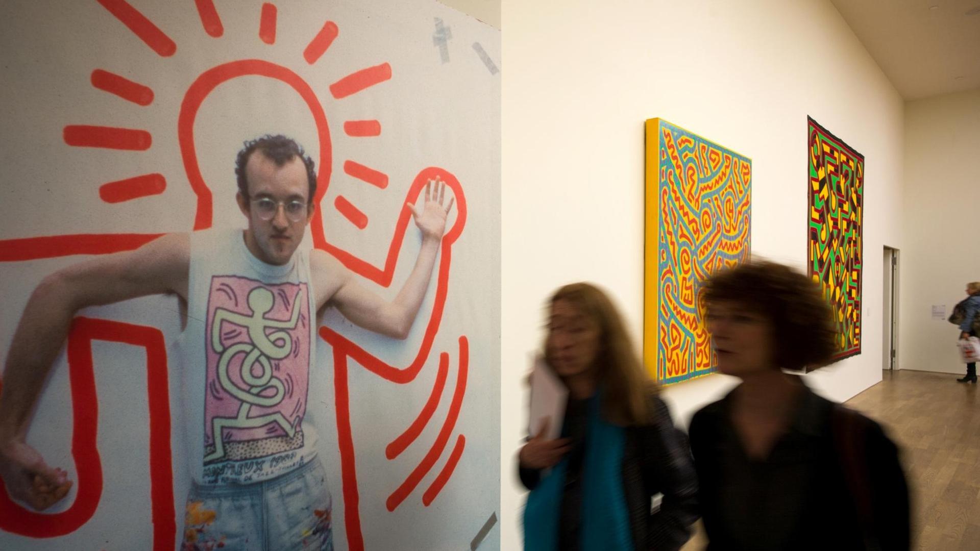 Besucherinnen schauen sich die Ausstellung "Keith Haring - Gegen den Strich" in München (Bayern) an.