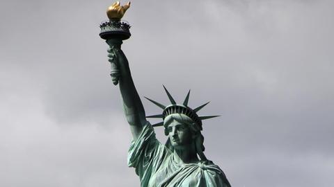Blick auf die Freiheitsstatue vor dunklen Wolken.