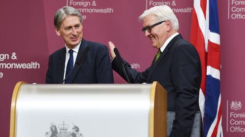 Der deutsche Außenminister Frank-Walter Steinmeier klopft seinem britischen Kollegen Philip Hammond (l.) mit der Hand auf die Schulter.