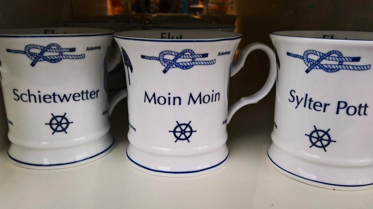 Kaffe-Tassen mit Aufschrift: Moin Moin, Schietwetter und Sylter Pott.