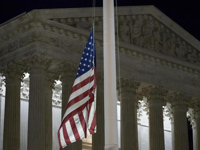 Das Gebäude des US-Verfassungsgerichts in der Nacht - die US-Flagge weht auf Halbmast.