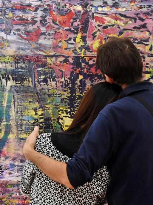 Ein Pärchen steht vor Gerhard Richters Werk Abstraktes Bild" (943-1),2016