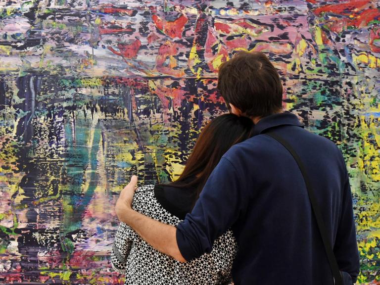 Ein Pärchen steht vor Gerhard Richters Werk Abstraktes Bild" (943-1),2016