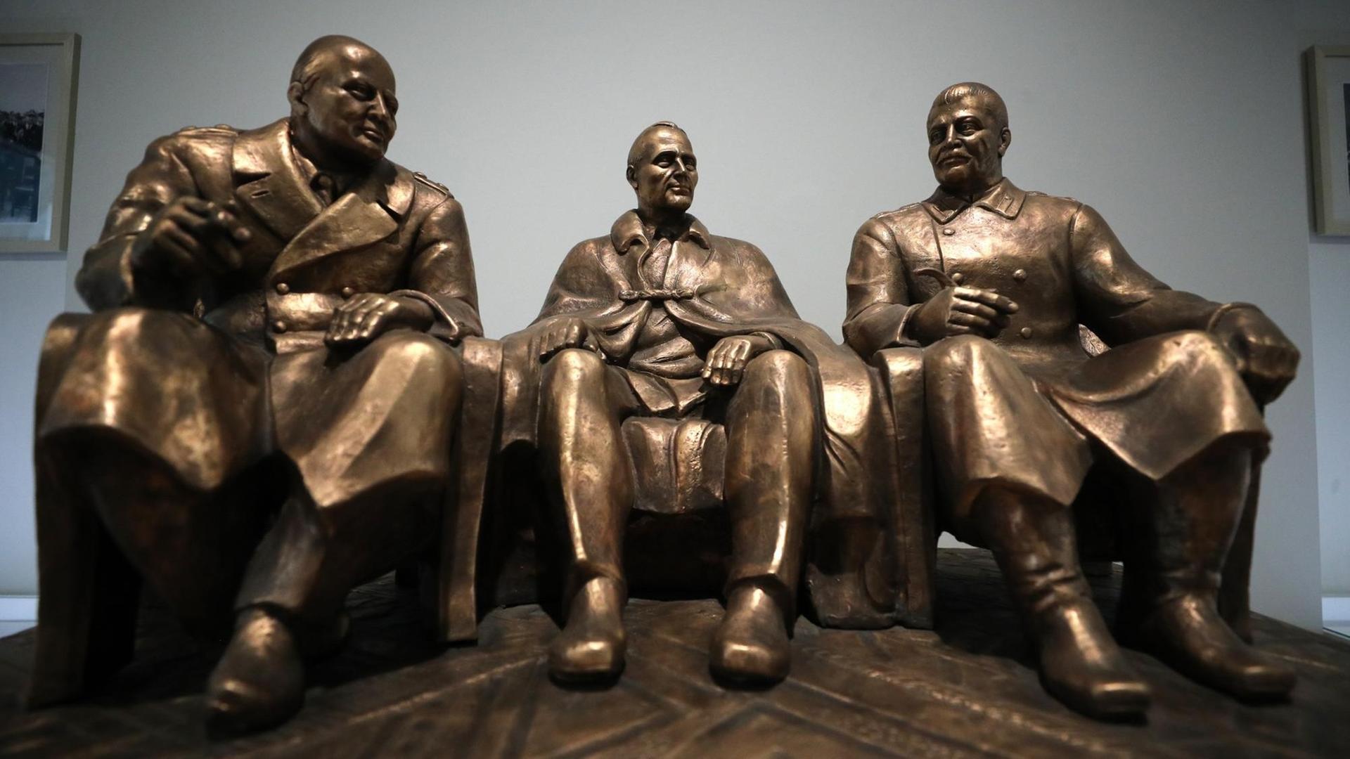 Eine Plastik zeigt die früheren Staatschefs Josef Stalin, Winston Churchill und Franklin D. Roosevelt einander zugewandt sitzend.