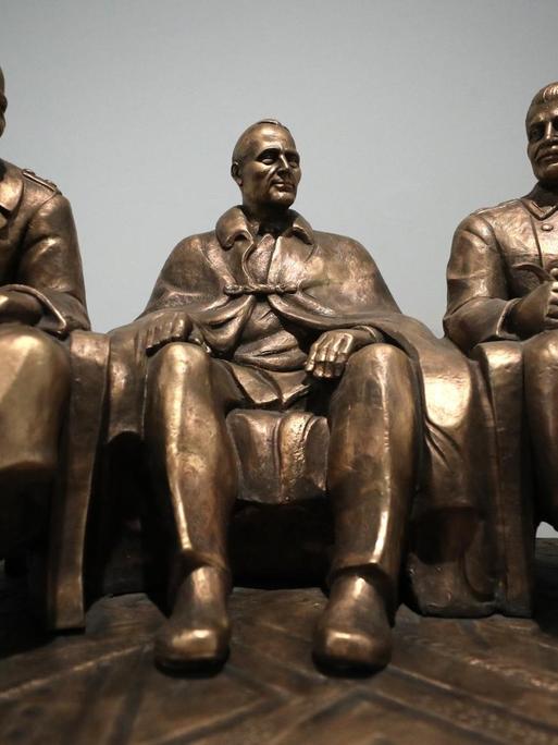 Eine Plastik zeigt die früheren Staatschefs Josef Stalin, Winston Churchill und Franklin D. Roosevelt einander zugewandt sitzend.