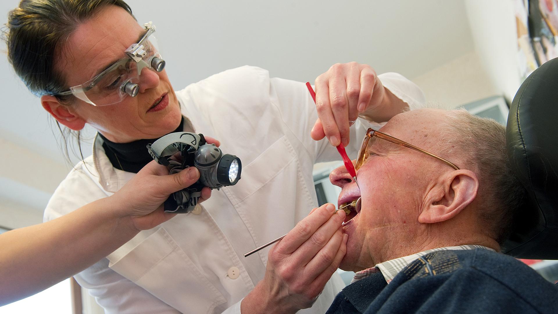 Die Zahnärztin Kerstin Finger behandelt einen Rentner in einem Seniorenheim im brandenburgischen Milmersdorf (Uckermark).