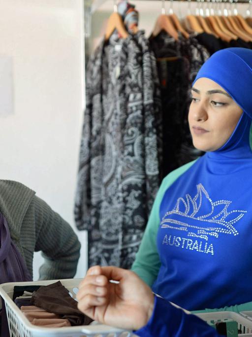 Die Designerin und Burkini-Erfinderin Aheda Zanetti, links, spricht mit Kundinnen in in ihrer Boutique in Sydney.