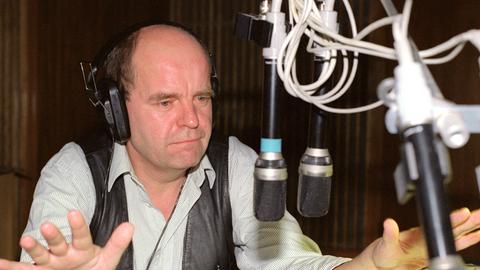 Kabarettist Martin Buchholz bei einer Studioaufnahme am Mikrofon. 