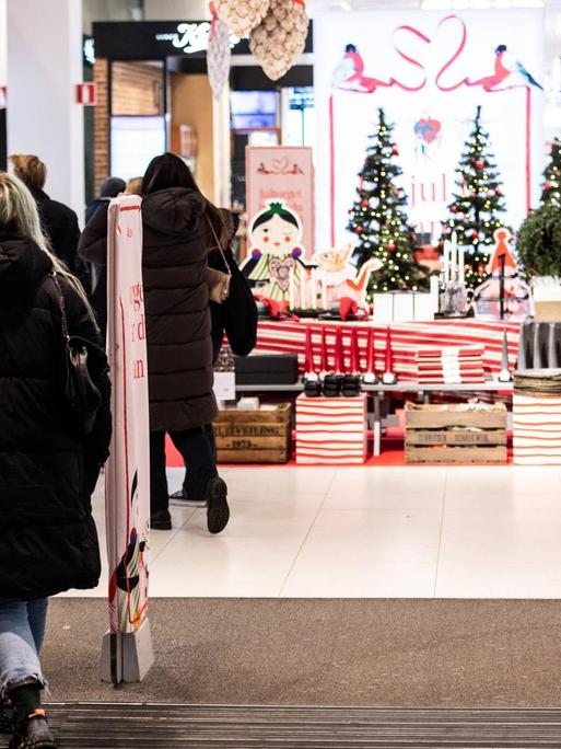 Kunden in einem weihnachtlich dekorierten Warenhaus in Stockholm tragen keinen Mund-Nasenschutz.
