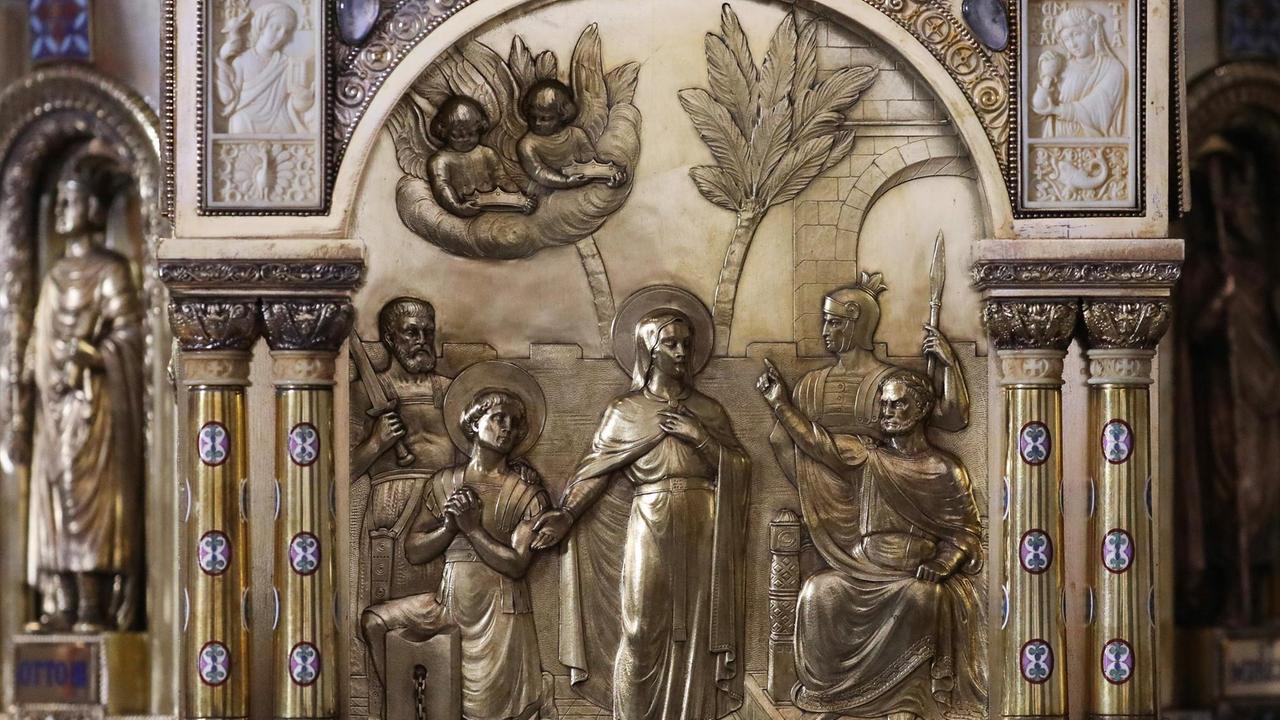 07.05.2020, Nordrhein-Westfalen, Aachen: Die Darstellung der Heiligen Corona (M) auf dem Schrein im Dommuseum in Aachen. Im Hintergrund sind zwei Palmen zu sehen. 