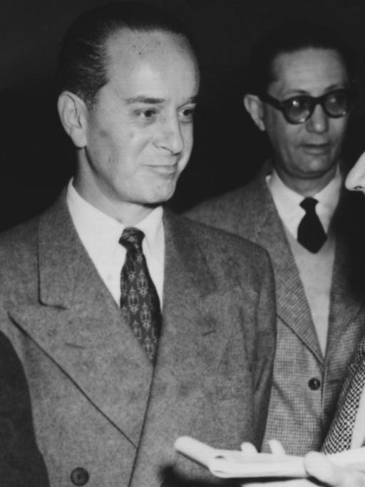 Der im Exil lebende ehemalige Präsident von Guatemala, Jacobo Arbenz Guzman (M), und seine Ehefrau (l) beantworten bei ihrem Aufenthalt in Paris am 4.1.1955 die Fragen von Journalisten. Arbenz war 1950 zum Staatspräsidenten von Guatemala gewählt worden. 1952 erließ er ein Gesetz zur Bodenreform, das die Enteignung der US-amerikanischen United Fruit Co. ermöglichte. 1954 wurde er gestürzt.