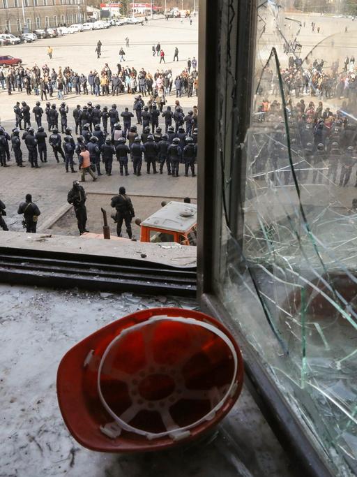 Polizisten stehen vor dem teilweise zerstörten Verwaltungsgebäude in Charkiw.