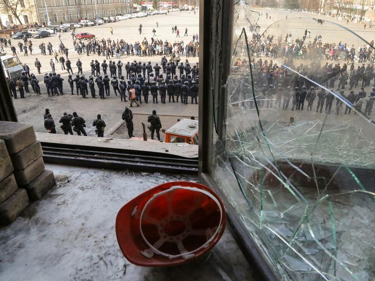 Polizisten stehen vor dem teilweise zerstörten Verwaltungsgebäude in Charkiw.