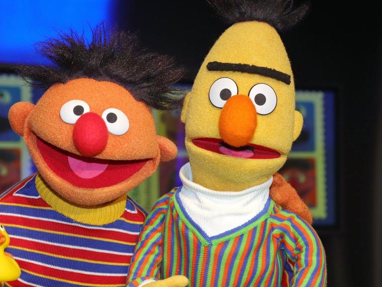 Ernie aus der Sesamstrasse hat den Arm um Bert gelegt und ein Quietscheentchen in der Hand.