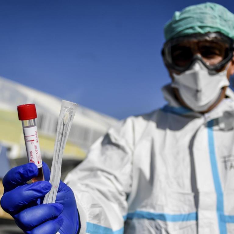 Ein medizinischer Mitarbeiter zeigt ein Testkit zur Prüfung von Infektionen auf den neuartigen Coronavirus. 
