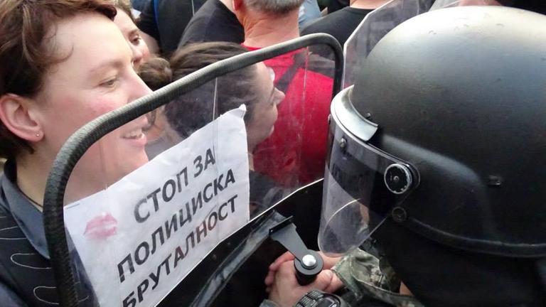 Demonstrantin und Polizist stehen sich gegenüber Demonstrantin und Polizist stehen sich gegenüber