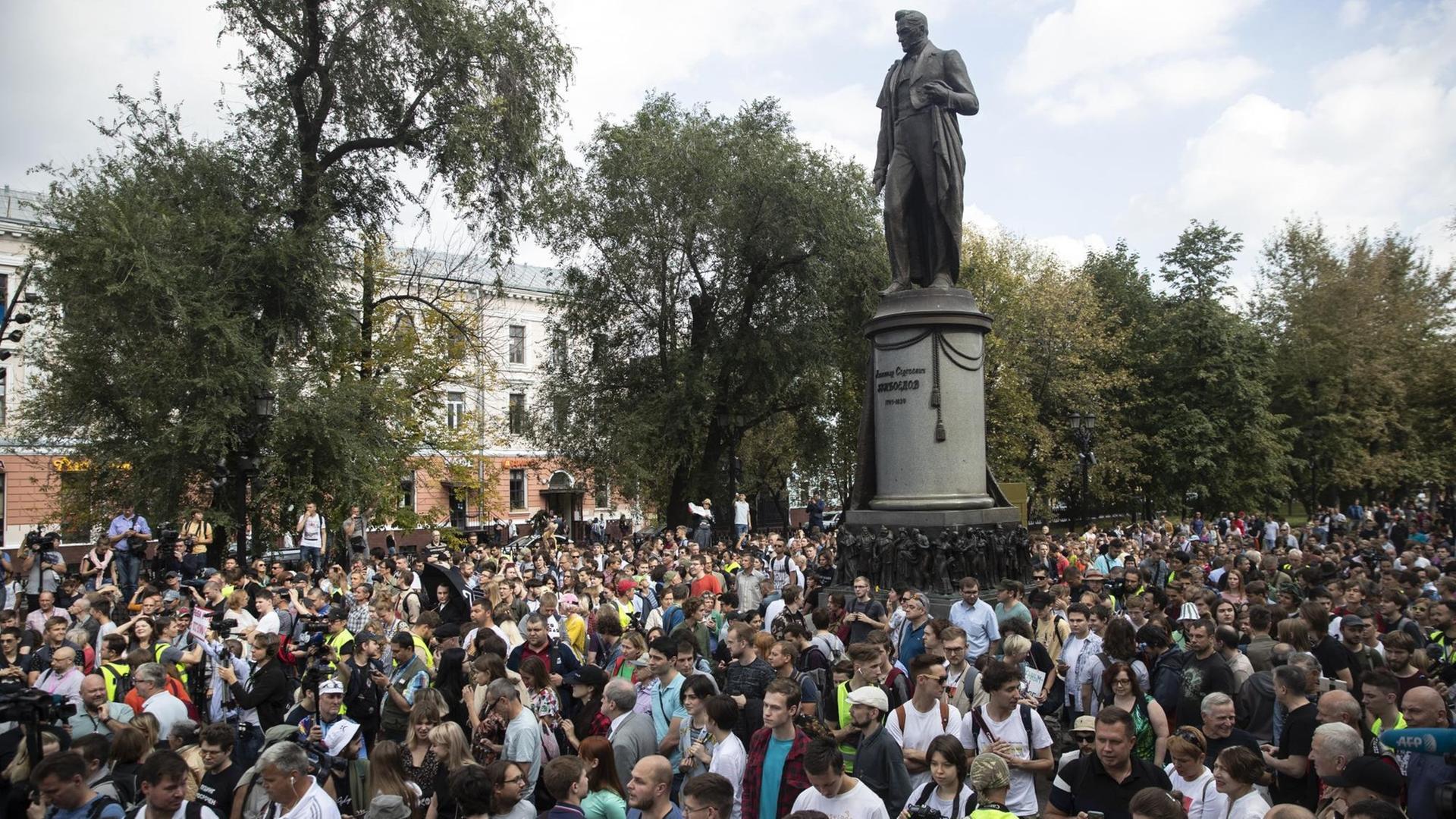 31.08.2019, Russland, Moskau: Menschen nehmen an einer Demonstration vor einer Statue des berühmten russischen Dichters Alexander Gribojedow teil. In der russischen Hauptstadt haben erneut Tausende Menschen für freie Wahlen demonstriert. Foto: Pavel Golovkin/AP/dpa +++ dpa-Bildfunk +++