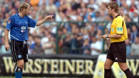 Hamburgs bosnischer Stürmer Sergej Barbarez (l) diskutiert nach dem zweiten Gegentreffer mit Schiedsrichter Robert Hoyzer. Fußball-Bundesligist Hamburger SV verliert am 21.08.2004 im Hermann-Löns-Stadion in Paderborn das DFB-Fußballpokalspiel der 1. Runde gegen den ostwestfälischen Regionalligisten SC Paderborn mit 2:4 und scheidet überraschend aus. | Verwendung weltweit