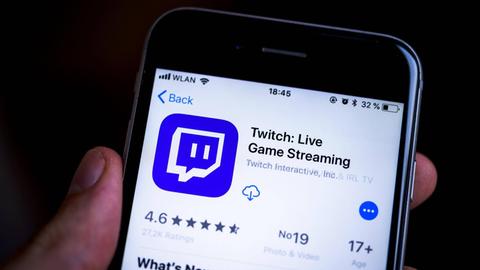 Hand hält Handy mit Twitch-App