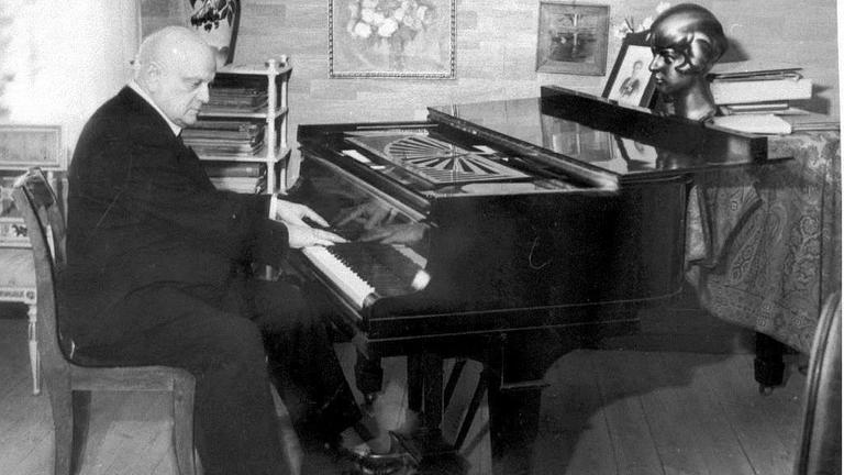 Der Komponist Jean Sibelius spielt am Flügel in seinem Arbeitszimmer