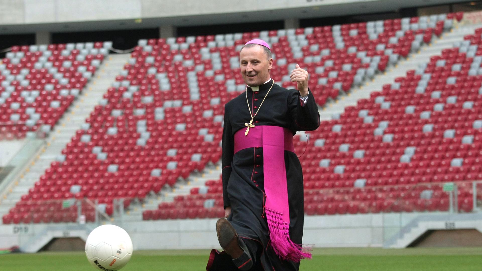 Der polnische Bischoff Marek Solarczyk kickt einen Fußball im Warschauer Nationalstadium. Zuvor hatte er eine Kapelle im Stadion eingeweiht.