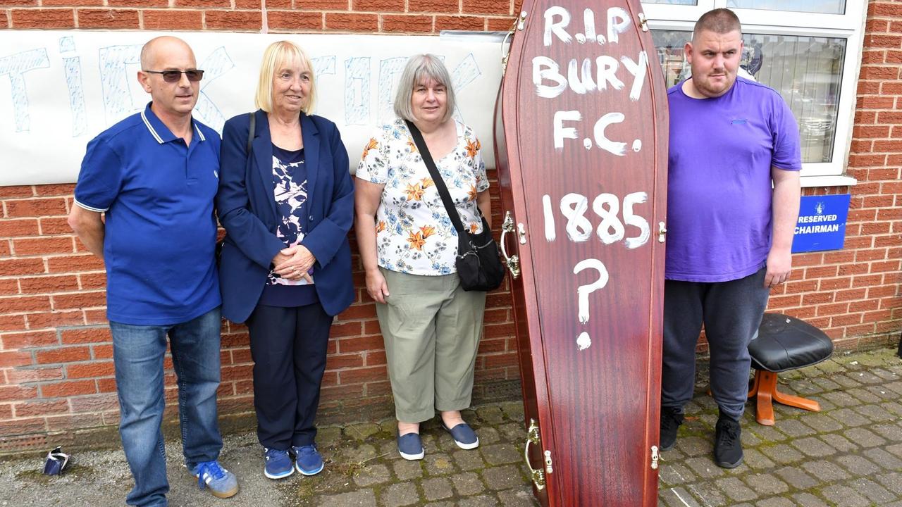 Fans des Fußballklubs Bury FC stehen am 23. August 2019 am Stadion Gigg Lane neben einem Sarg als Symbol für das Ende ihres Vereins. Auf den Sarg haben sie "RIP Bury F.C. 1885?" geschrieben.
