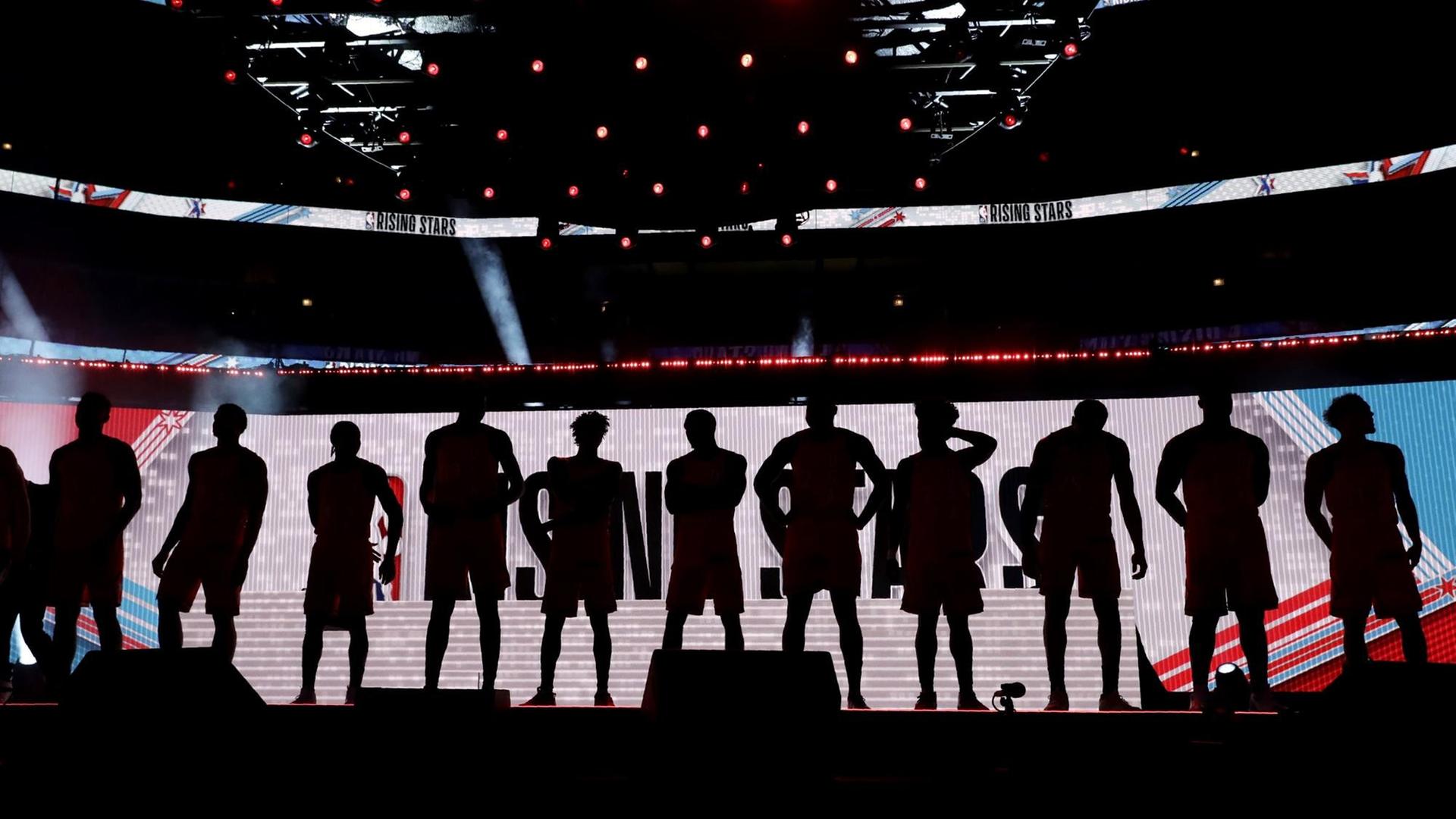 Die Mitglieder des US-Basketballteams sind als Silhouetten nebeneinander stehend zu sehen.