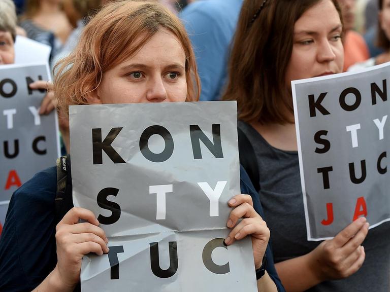 Demonstranten halten am 23.7.2017 vor dem Präsidentenpalast in Warschau Poster mit der Aufschrift "Verfassung" (auf Polnisch) in die Höhe.