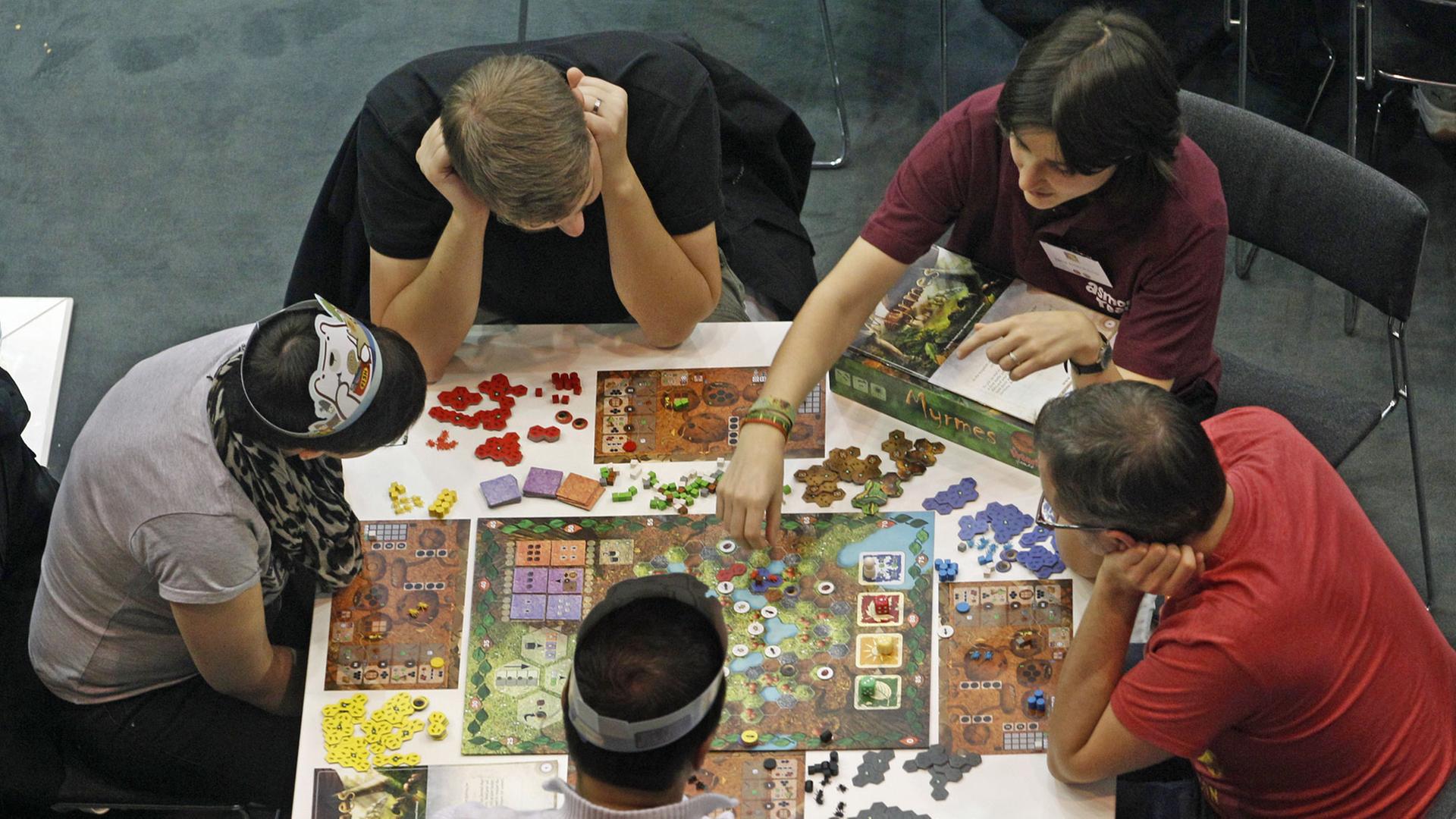 Besucher der "Spiel '13" Messe in Essen (Nordrhein-Westfalen) testen am 24.10.2013 ein Brettspiel. Auf der Spielmesse zeigen über 800 Aussteller aus 39 Nationen ihre Spielneuheiten