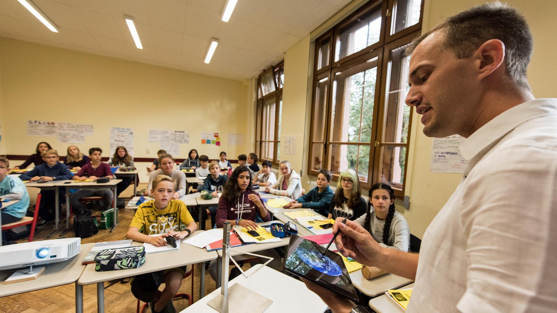 Friedrich-Gymnasium in Freiburg / Baden-Württemberg: Physiklehrer Patrick Bronner unterrichtet seine Klasse in einem Pilotprojekt mit einem Tabletcomputer. Die Schüler erarbeiten Ergebnisse mit dem Smartphone.