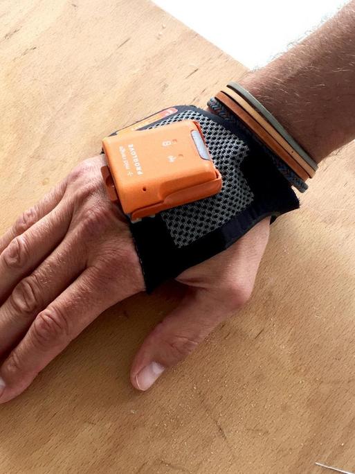Ein Proglove Scanner-Handschuh, der an einer Hand befestigt ist.